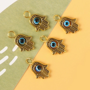 Five golden Hamsa Hand pendants with blue Evil Eye beads for DIY jewelry making