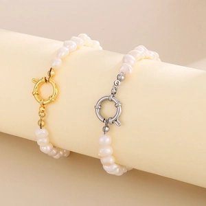 Détail d'un bracelet en perles baroques avec fermoirs à bascule dorés et argentés