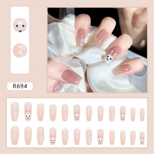 Nude pink press-on nails with cute white rabbit design and long coffin shape