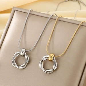 Detail of silver and gold interlaced circular pendants on snake chains over a gold display