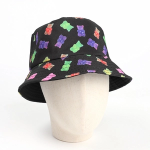 Detailed close-up of a black bucket hat featuring colorful gummy bear patterns on white model