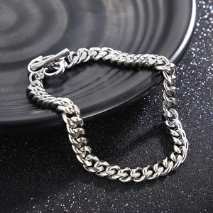 Gros plan du bracelet gourmette en acier titane argenté avec fermoir OT sur plat