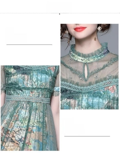 Detail of light green mesh dress showing embroidered floral patterns and ruffled neckline