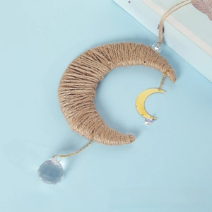 Detail of bohemian crescent moon decor with woven rope and faceted crystal pendant