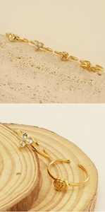 Dettaglio di anelli d'oro regolabili con farfalla, cuore e fiori in zircone