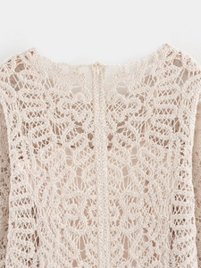 Detalle del tejido de ganchillo calado y cremallera invisible en un vestido beige suave