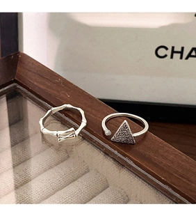 Detalle de anillo de plata S925 estilo bambú y banda con textura triangular