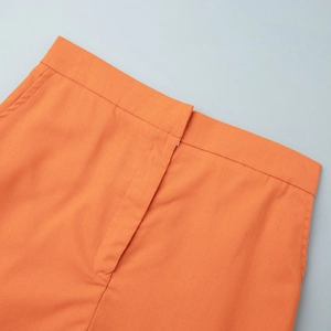 Detailed close-up of the bright orange cotton linen skirt waist and hidden closure