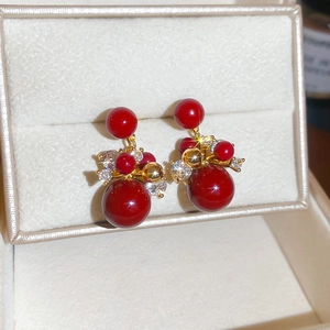 Macro detail of red zircon earrings with gold plating in a luxury jewelry box