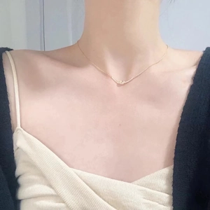 Elegant S925 silver bow necklace in gold finish worn on woman's neckline