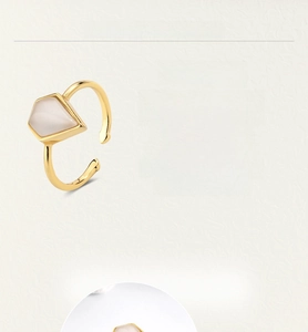 Detail of minimalist gold-plated ring with pentagonal white opal gemstone inlay