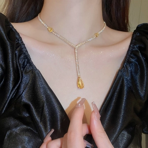 Vue détaillée du collier doré en Y avec cristaux de goutte jaune porté par un mannequin