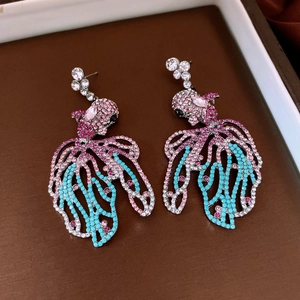 Détail de boucles d'oreilles poisson avec cristaux colorés et finition argentée vintage