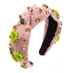 Close-up of pink satin knotted headband with colorful rhinestones and floral details