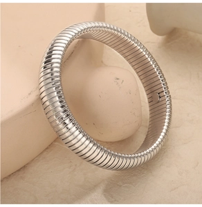 Detail of silver tubogas spiral bracelet showing flexible metallic texture and craftsmanship