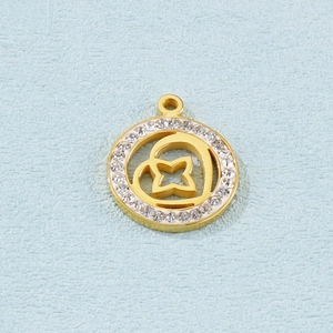 Detail of a gold circular charm with clear crystals and a hollow star center