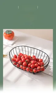 Detail of a black metal wire fruit bowl casting elegant shadows on a white table