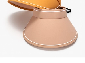 Détail de la sangle réglable et du tissu respirant des visières pare-soleil en orange et beige