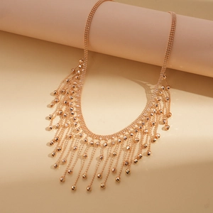 Detailed macro view of multi-layer rose gold tassel necklace with delicate bead accents