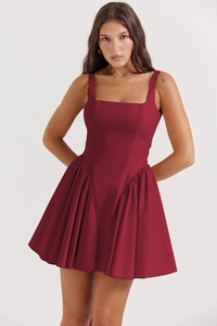 Detail des Karree-Ausschnitts und Faltenrocksaums an einem weinroten Minikleid