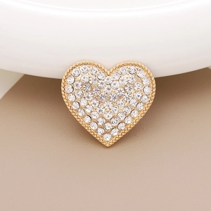 Close-up of heart-shaped gold accessory with sparkling rhinestones and pearls
