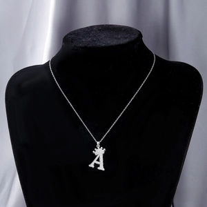 Macro detail of silver crown letter A pendant with sparkling cubic zirconia on a mannequin