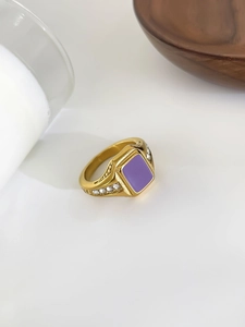 Close-up of gold stainless steel ring featuring a purple square inlay and side zircons