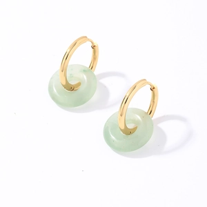 Détail de boucles d'oreilles créoles en acier doré avec pendentifs en pierre naturelle verte