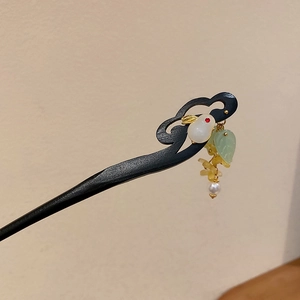 Détail d'une épingle à cheveux en bois avec pendentif lapin en jade et pompons