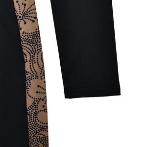 Detail shot of black long sleeve jumpsuit with brown polka dot mesh patchwork design