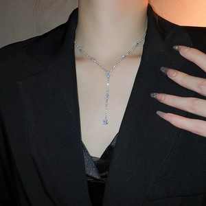 Close-up of elegant silver Y-shaped drop necklace with faceted crystals on a model