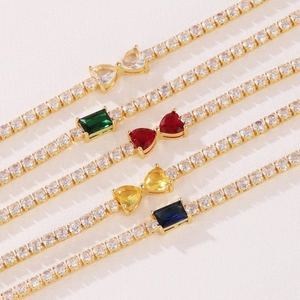 Close-up of gold plated tennis bracelets with colorful CZ stones in bow and rectangle shapes