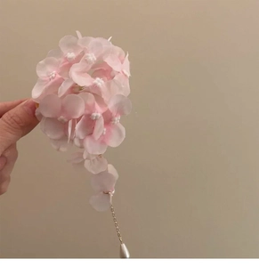 Detail of pink fabric flower hair clip with golden chain and teardrop pearl tassel