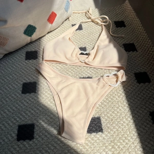 Detail of waffle textured fabric bikini with heart-shaped ring accents and tie neck straps
