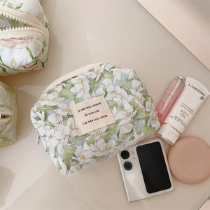 Flat lay of floral cotton makeup bag with beige zipper and small flower patterns