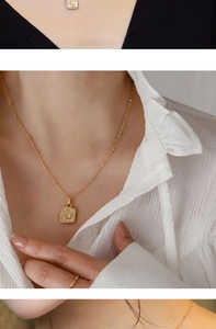 Détail du collier vintage doré avec pendentif papillon en nacre sur le cou d'une femme