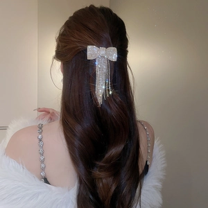 Gros plan d'une barrette à cheveux nœud en strass avec pampilles sur cheveux longs
