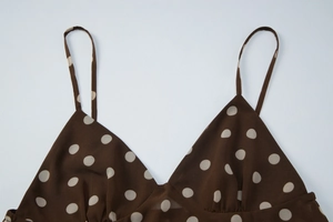 Gros plan sur le caraco marron à pois avec décolleté en V et fines bretelles spaghetti