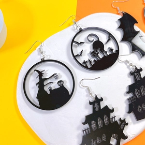 Detail of Halloween acrylic earrings featuring black witch, bat, and castle cutouts
