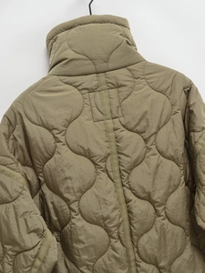 Detail of olive green quilted jacket showing wavy patterns and high stand collar back