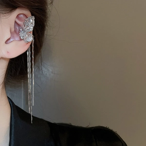 Close-up of silver butterfly ear cuff with sparkling zircons and long tassel chains
