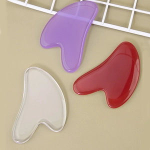 Three-piece resin heart gua sha tools in clear, purple, and red for facial massage