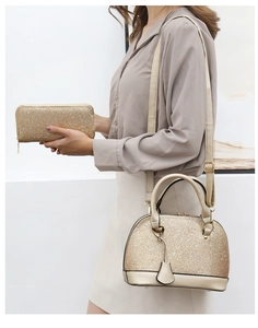 Detail shot of a shimmering gold shell handbag and matching long zipper wallet set