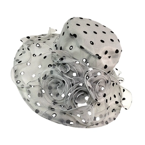 Detailed view of silver sun hat featuring black polka dots and layered floral mesh decoration