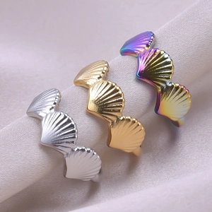 Detailed view of fan-shaped shell rings in gold and silver on soft silk fabric