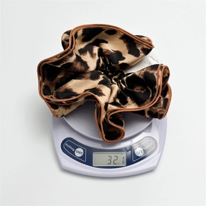 Double-layered leopard print oversized scrunchie weighing 32.1g on a digital scale