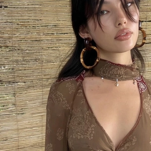 Bohemian large bamboo hoop earrings with amber resin links on a stylish female model