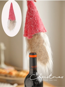 Detail of red plush gnome wine bottle topper with faux fur beard for Christmas decor