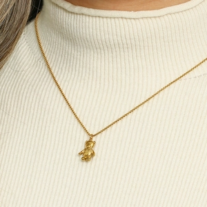 Minimalist 18K gold plated stainless steel balloon dog pendant necklace worn by a model
