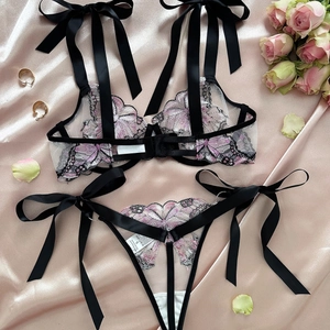 Sexy black lace lingerie set with butterfly embroidery and satin ribbons on pink silk